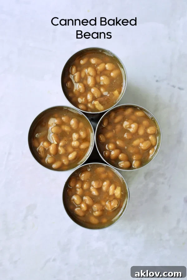 Overhead photo of four cans of opened canned baked beans.