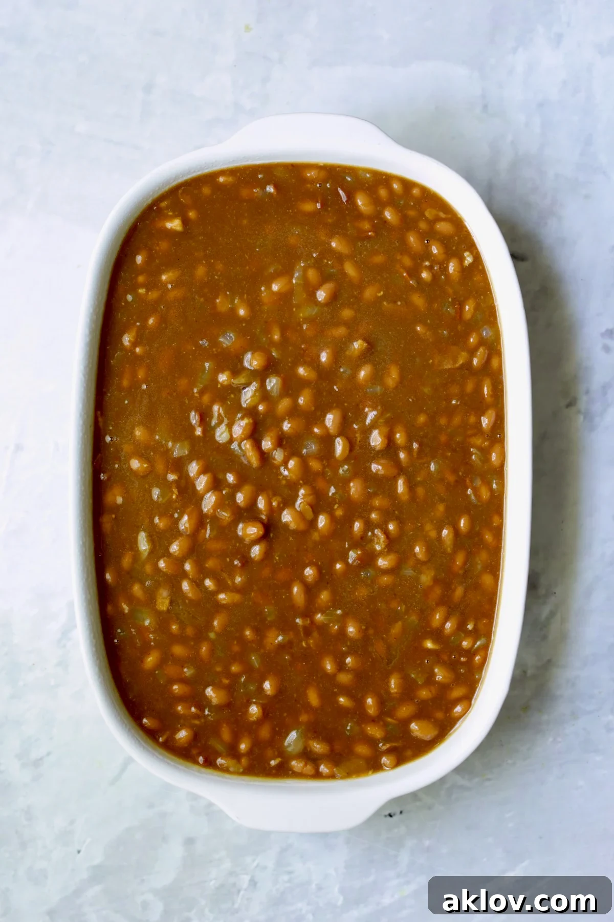 Baked beans in white oval baking dish.