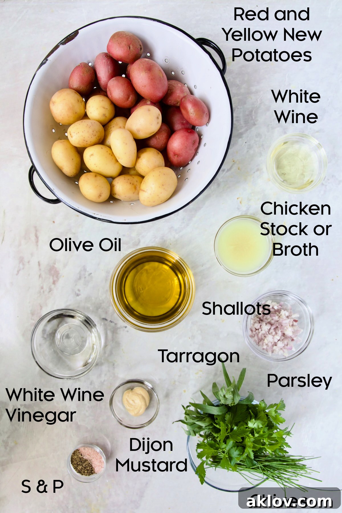 Various ingredients for French Potato Salad neatly arranged in small glass bowls, including potatoes, herbs, and liquids.