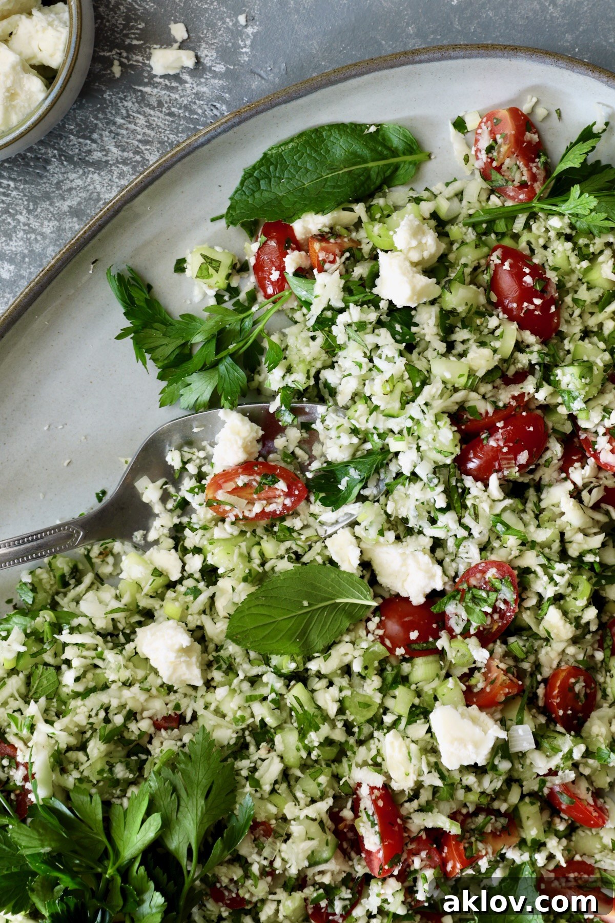 Close-up of Cauliflower Tabbouleh on a platter, highlighting the fresh herbs and vegetables.