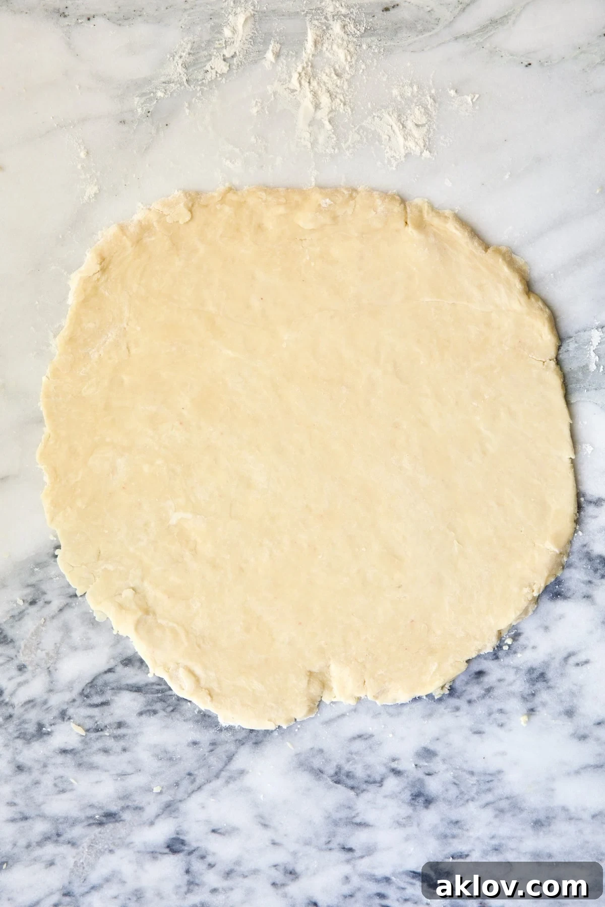 Galette dough on white marble pastry board.