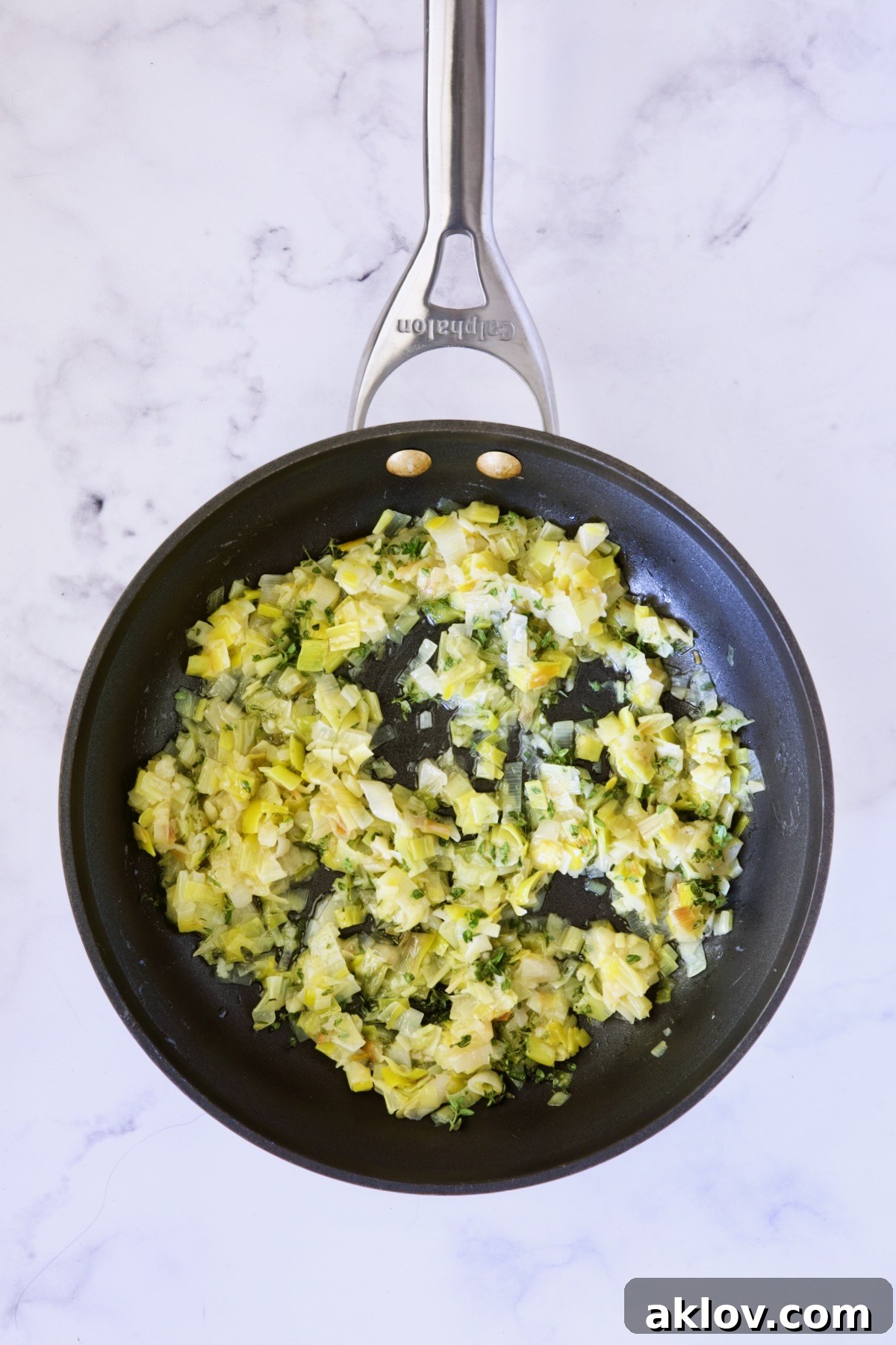 Tender, cooked leeks, softened and slightly caramelized, ready to be incorporated into the galette filling, presented in a nonstick skillet.