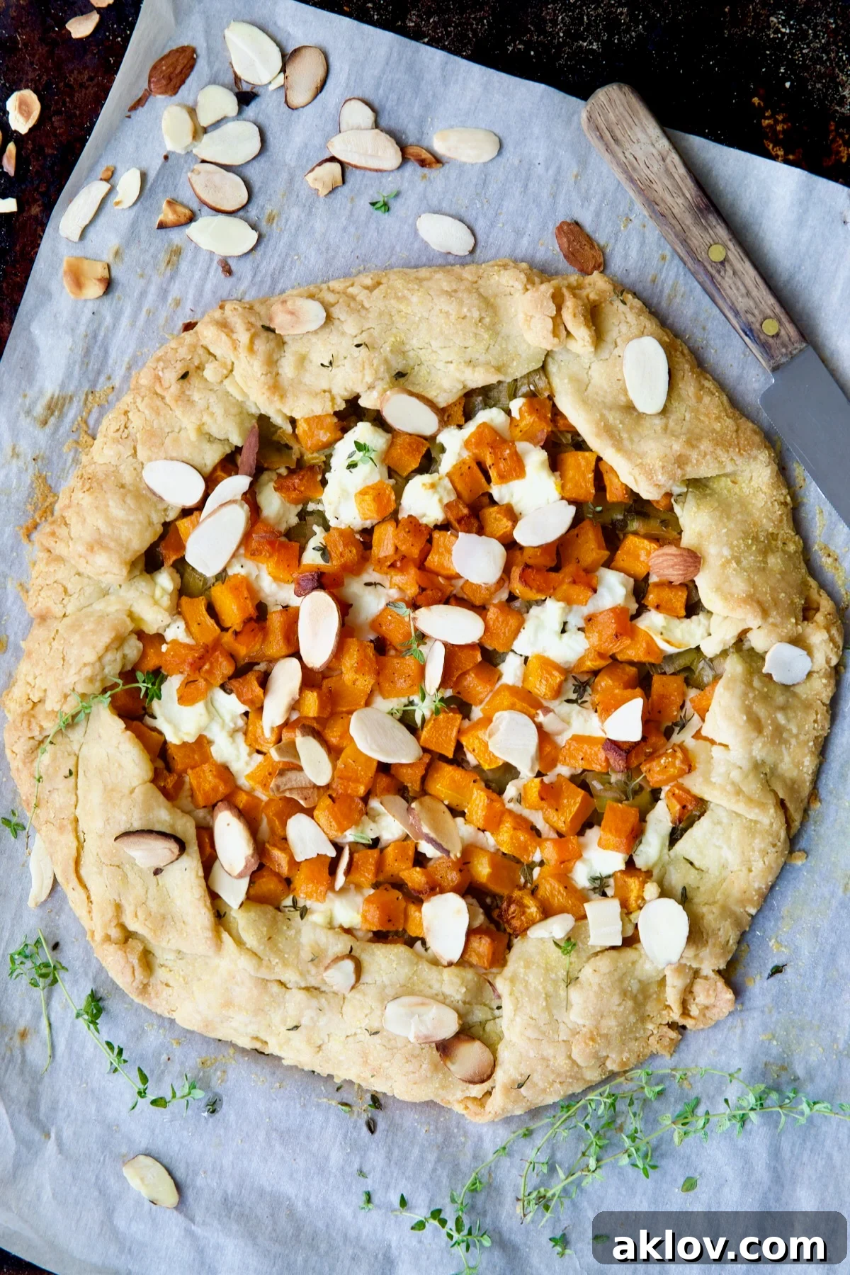 Baked Butternut Squash Leek and Goat Cheese Galette on white parchment paper.