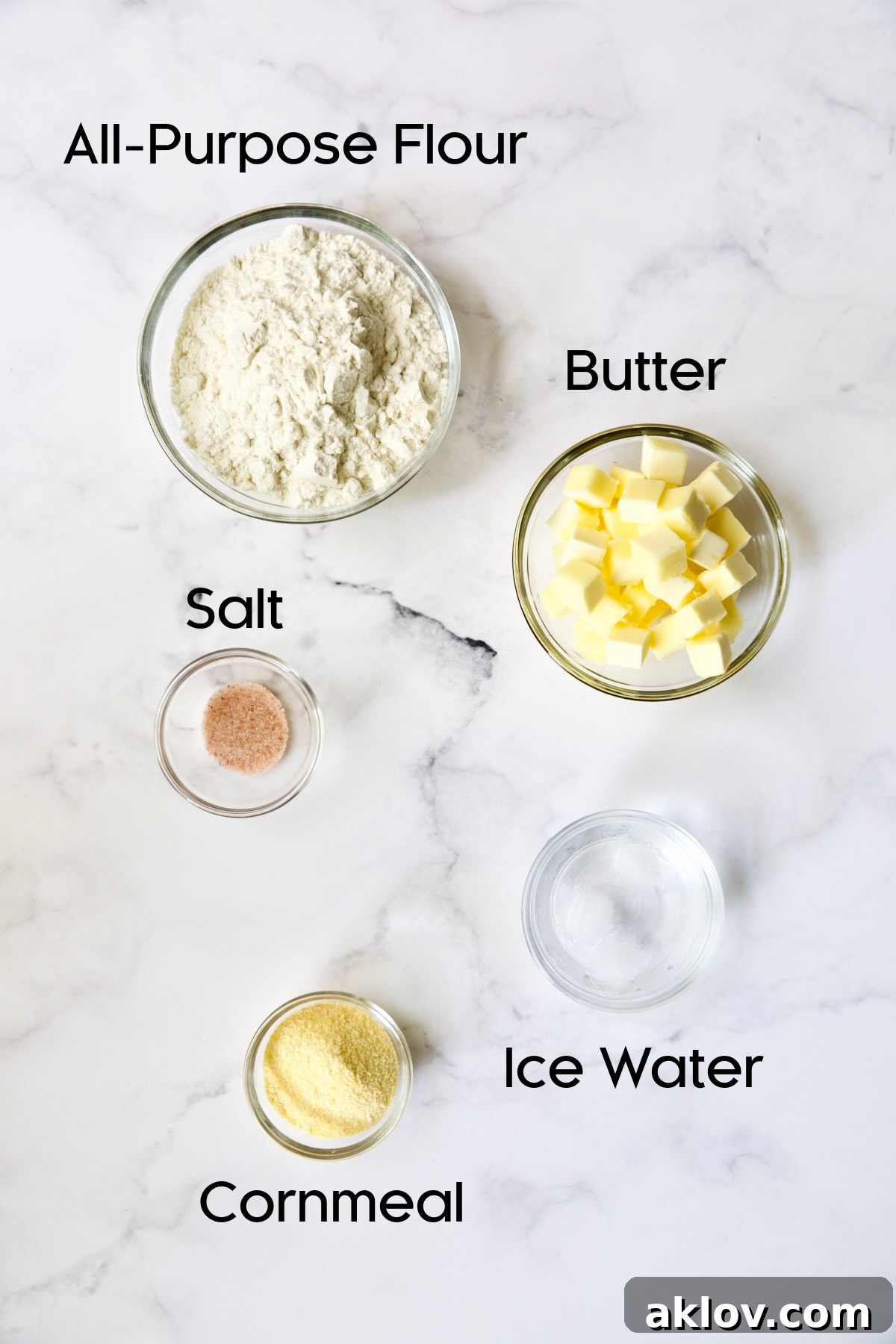 A collection of ingredients for the galette dough, including flour, butter, and salt, presented in elegant glass bowls.