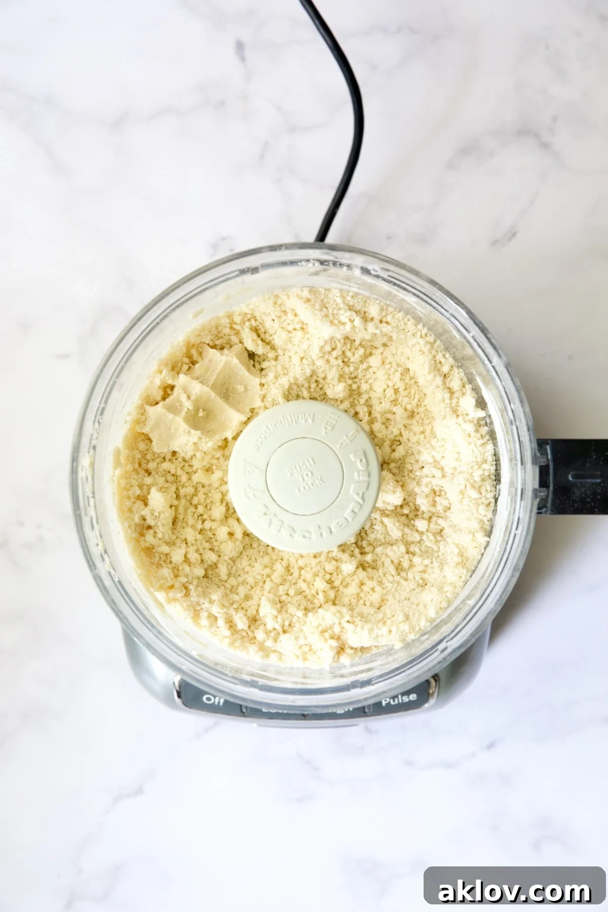 Ingredients for galette dough in food processor with some pinched together to show it will hold together.
