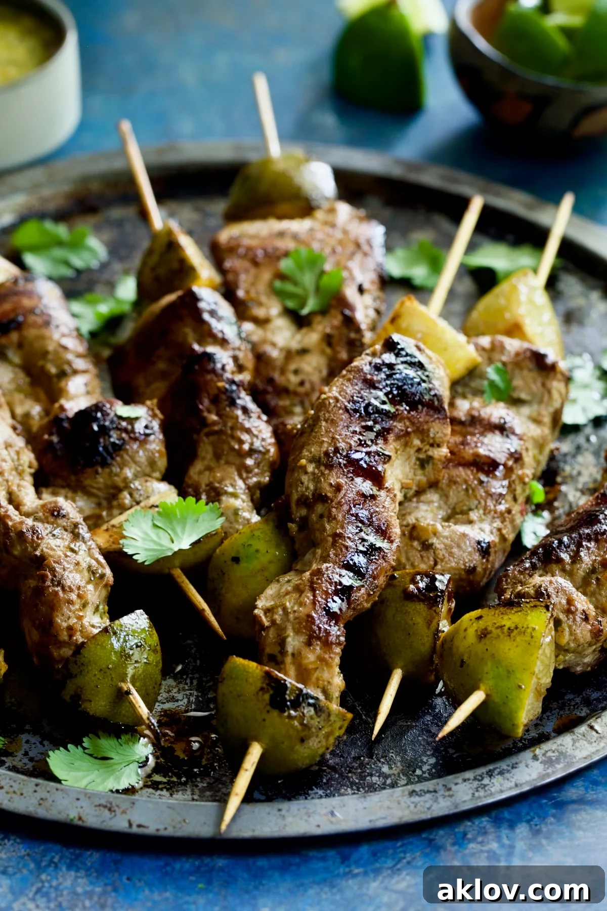 Perfectly grilled Mojo-Marinated Pork Skewers arranged neatly on a metal tray.