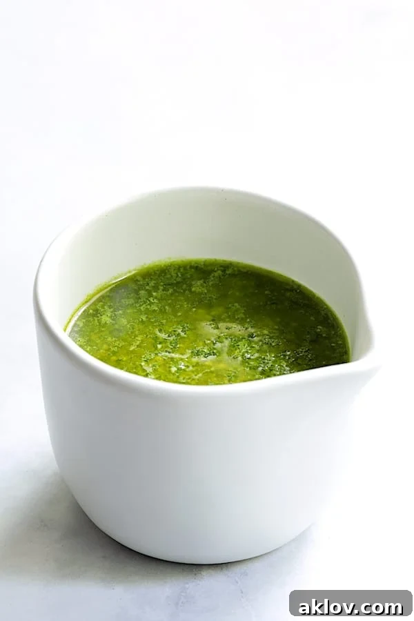 Freshly made basil pesto dressing elegantly presented in a small white pitcher.