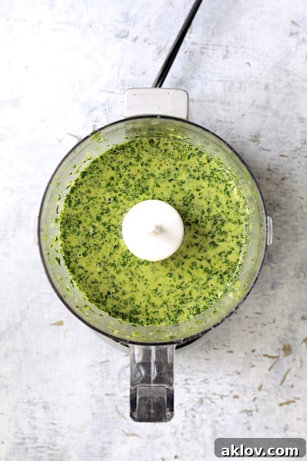 The vibrant green cilantro-lime dressing being blended in a food processor, creating a smooth and aromatic mixture.