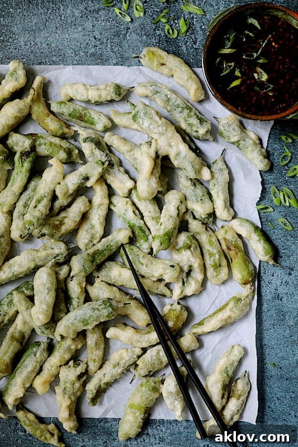 Crispy Beer Batter Shishito Pepper Tempura with Spicy Garlic Dipping Sauce, garnished with thinly sliced scallions.