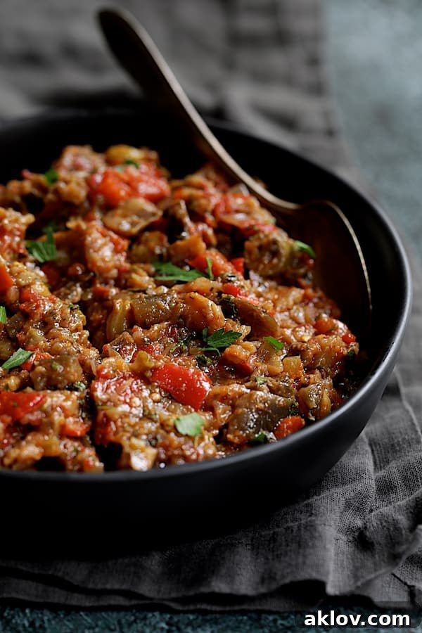 Close-up photo of Moroccan-Spiced Caponata elegantly presented in a black serving bowl with a spoon, highlighting its vibrant appearance.