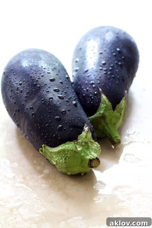 Photo of whole, freshly washed eggplants, ready for preparation.
