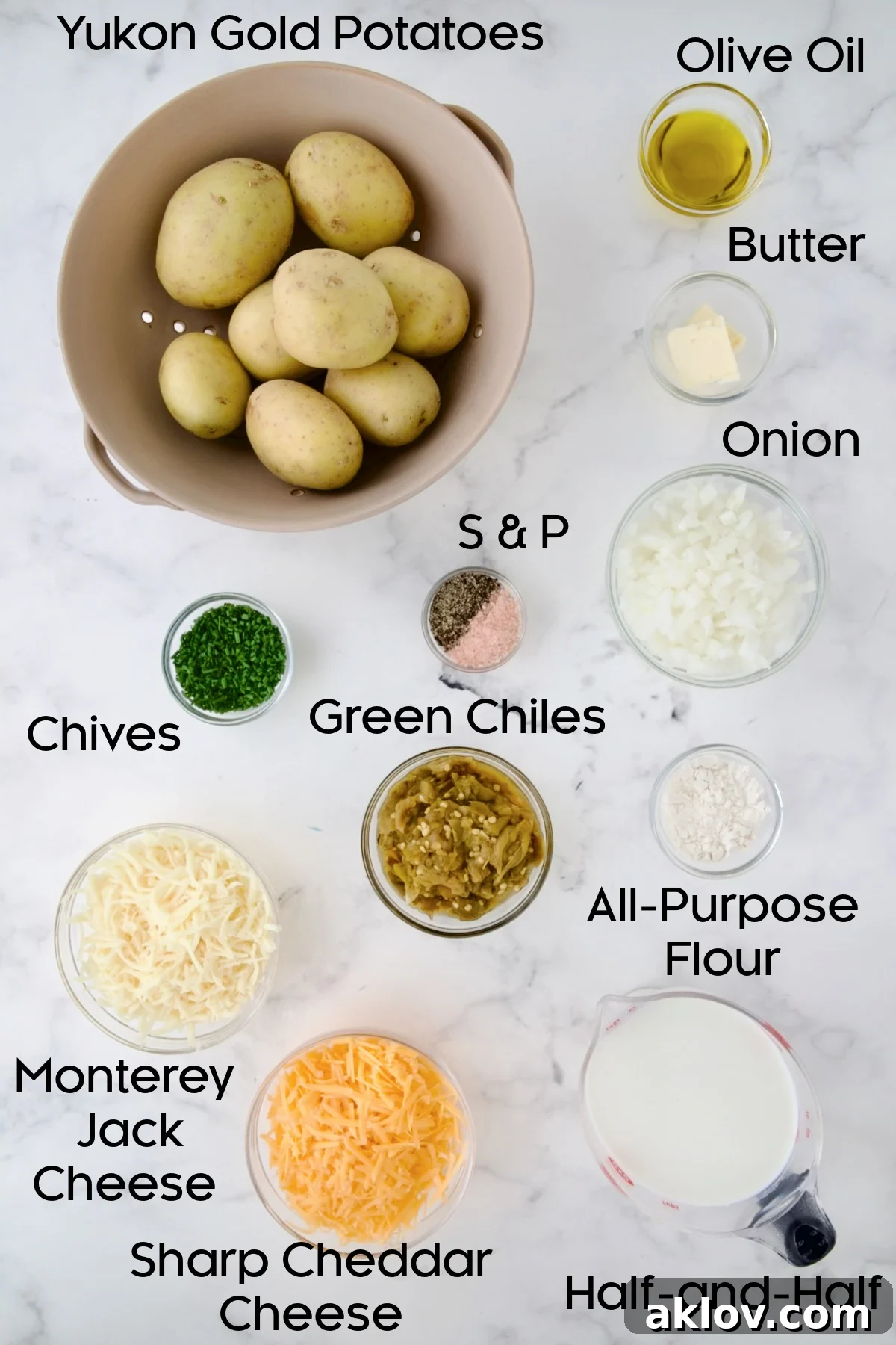 A selection of fresh ingredients laid out in glass bowls, including cubed Yukon Gold potatoes, finely chopped onion, shredded Monterey Jack and sharp Cheddar cheeses, half-and-half, butter, olive oil, and a bowl of vibrant green chiles. These are the key components for making Hatch Green Chile au Gratin Potatoes.