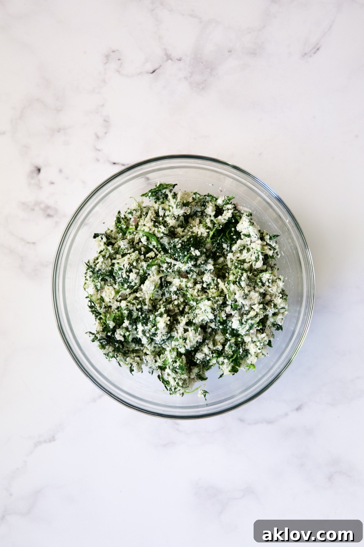 Well-mixed spinach and ricotta filling in a glass bowl, ready to be spread.