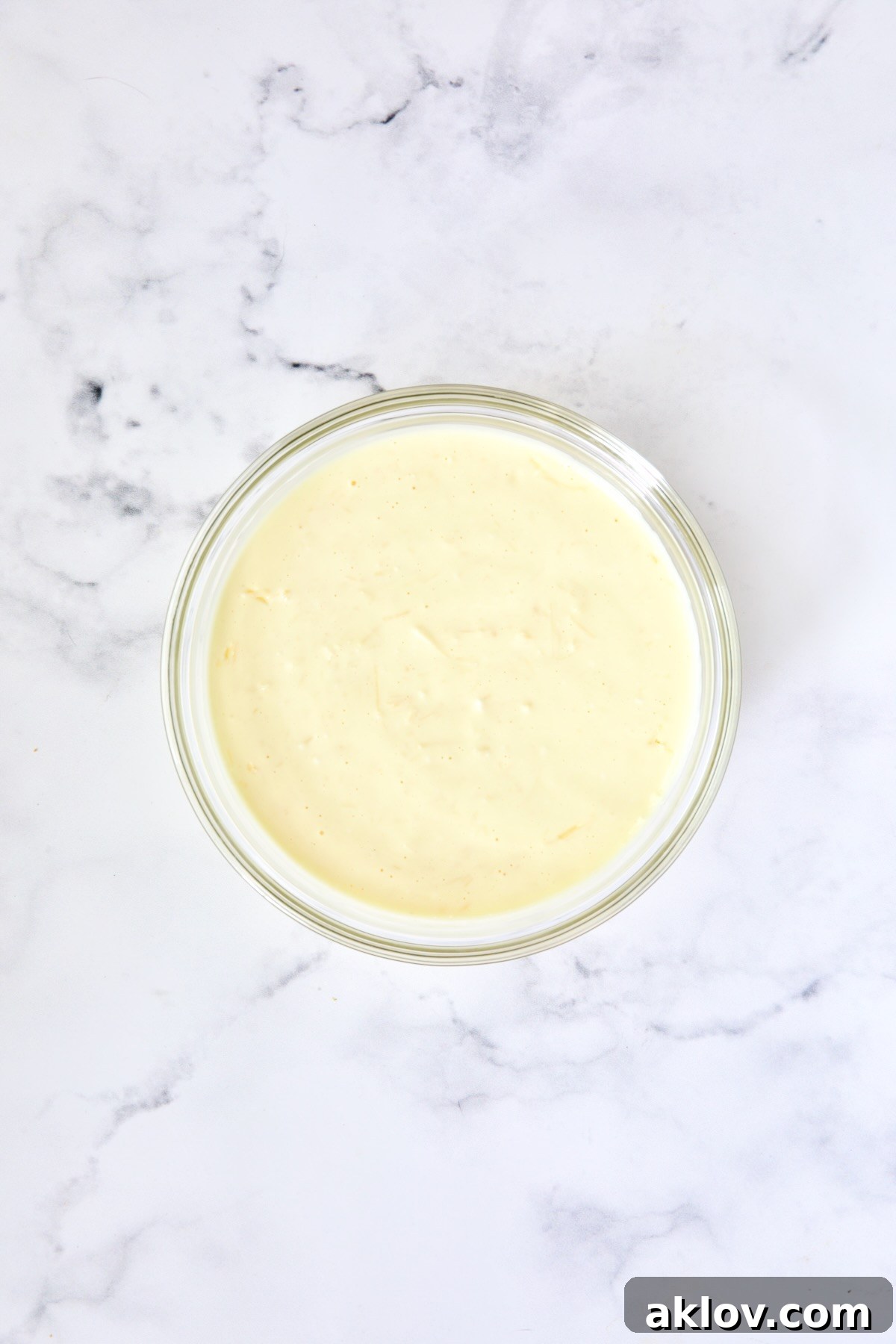 Mayonnaise, egg, cream cheese and Parmesan cheese combination in glass bowl.