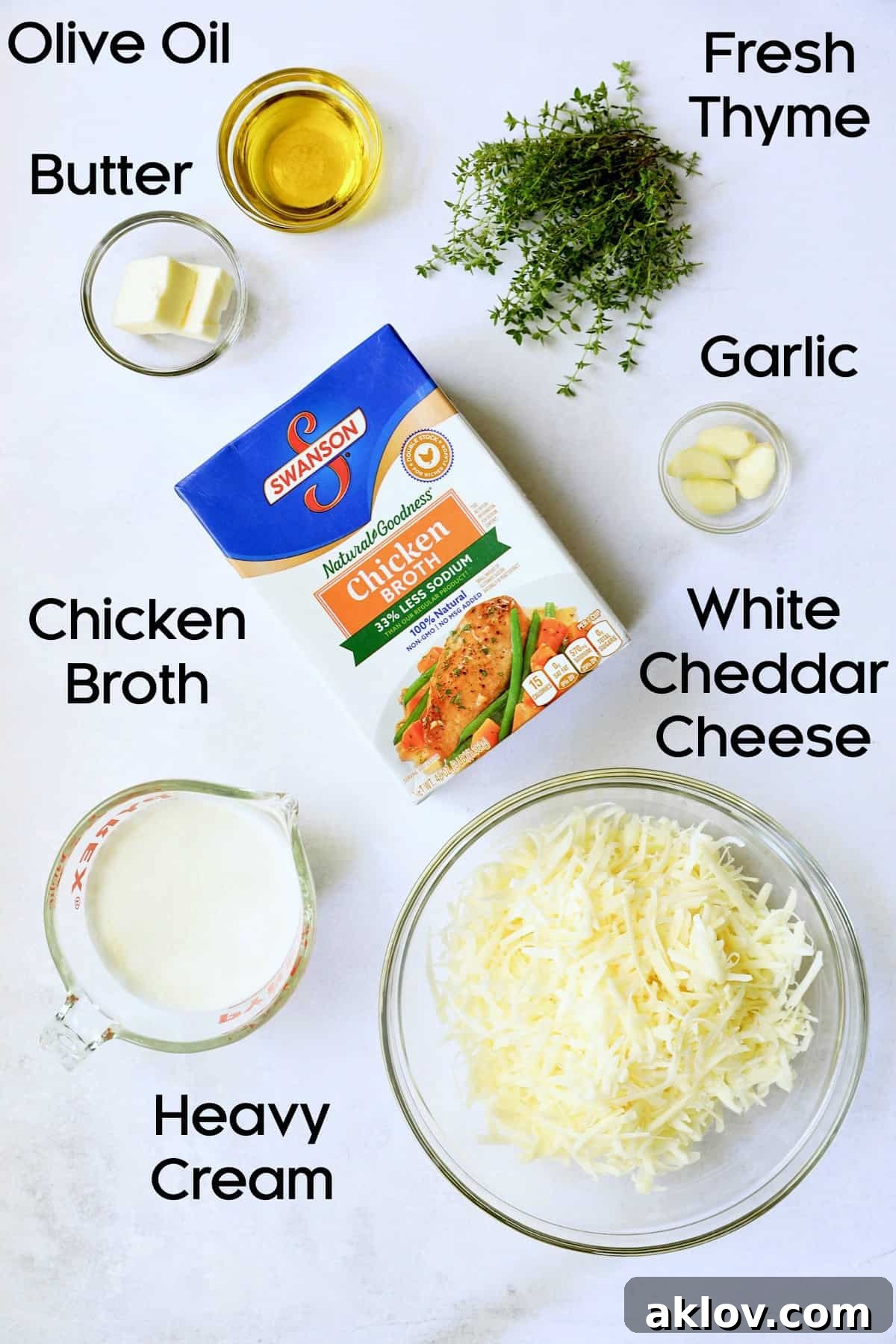 A collection of fresh ingredients for Potato Leek Soup with White Cheddar, neatly arranged in glass bowls, featuring leeks, potatoes, garlic, and cheddar cheese.