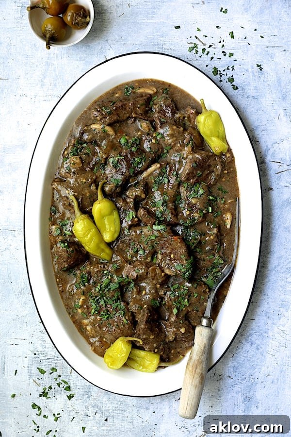 Photo of Mississippi-Style Boneless Short Ribs on white platter garnished with peppers and parsley.