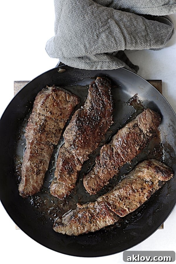 Photo of browned boneless short ribs in black skillet.