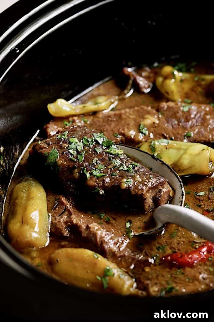 Close-up photo of Mississippi-Style Boneless Short Ribs Without Packaged Mixes being lifted out from slow cooker.