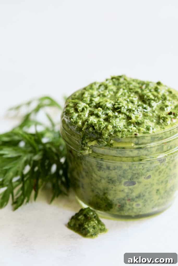 Photo of Carrot Top Salsa Verde in a glass jar, with some sauce drizzled on the surface, showcasing its texture.