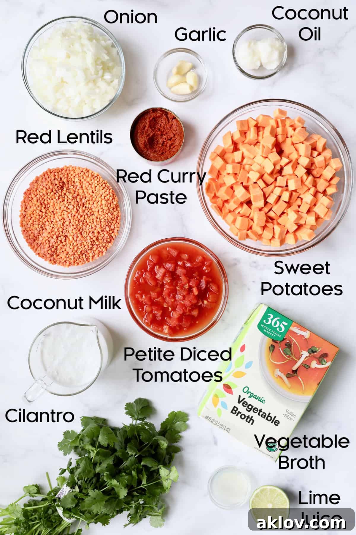 Various fresh ingredients for Thai Red Curry Sweet Potato and Lentil Soup arranged in glass bowls, including red curry paste, lentils, sweet potatoes, onions, garlic, and coconut milk.