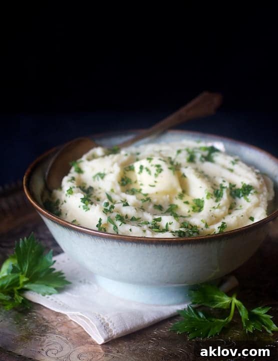 Celery root puree in bowl garnished with fresh chopped parsley.
