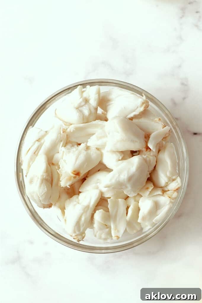 Close-up photo of high-quality lump crabmeat in a clear glass bowl, showcasing its fresh texture.