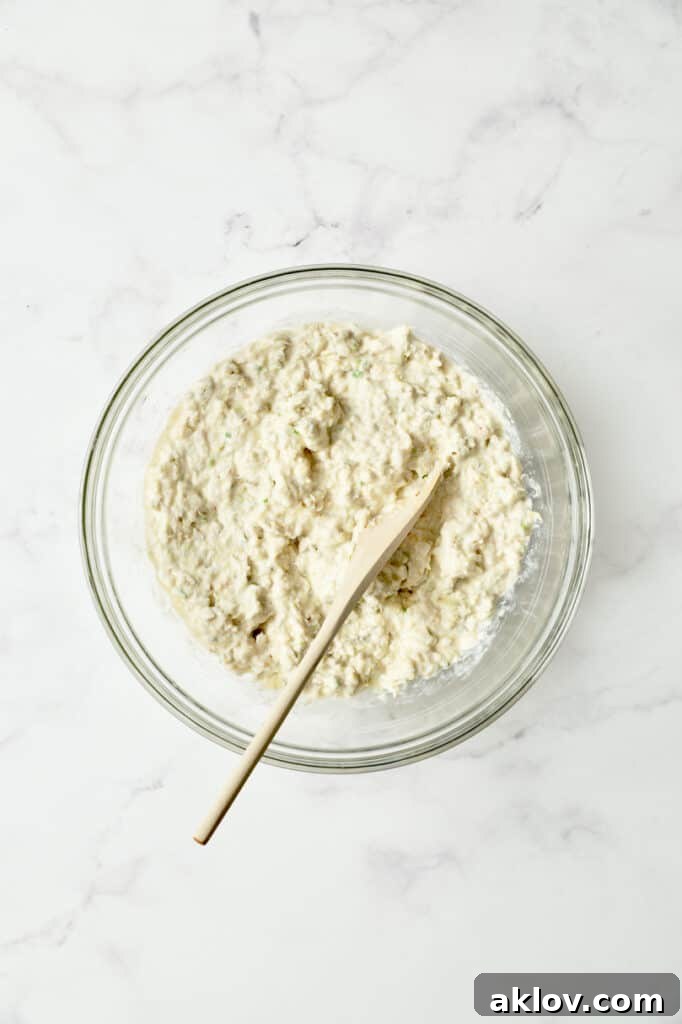 Photo of Crab and Artichoke Beignet batter perfectly combined in a glass bowl, showcasing its consistency.
