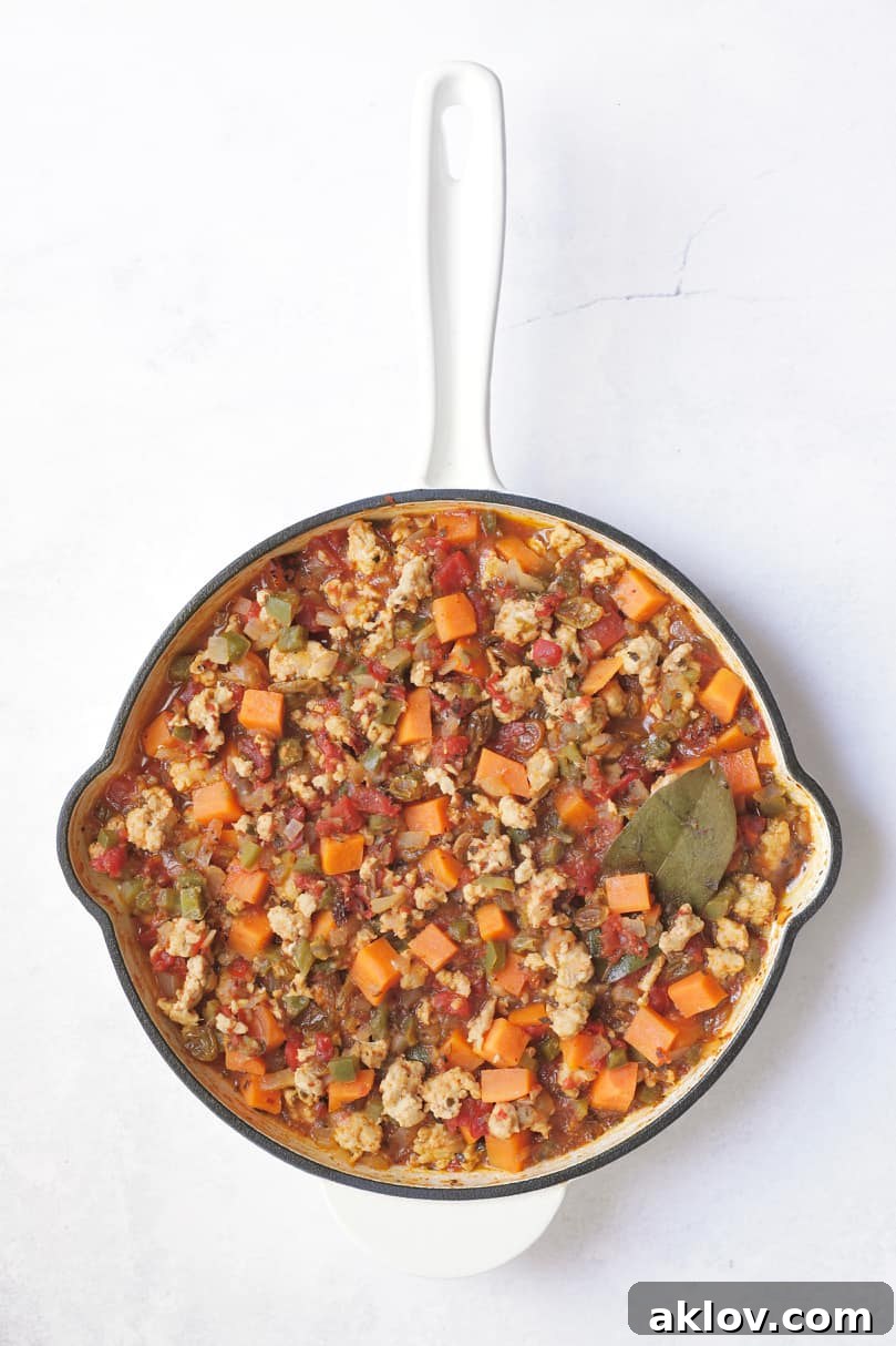 Remaining ingredients for picadillo combined and cooked.
