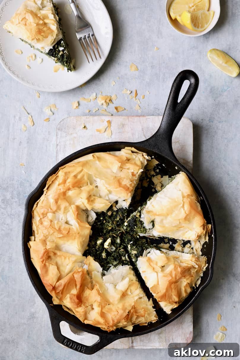 Skillet Spanakopita with Spinach and Feta 17 Photo of Skillet Spanakopita (Greek Spinach and Feta Pie) with a piece removed to a plate, ready to be enjoyed. This image emphasizes serving and enjoying the dish.