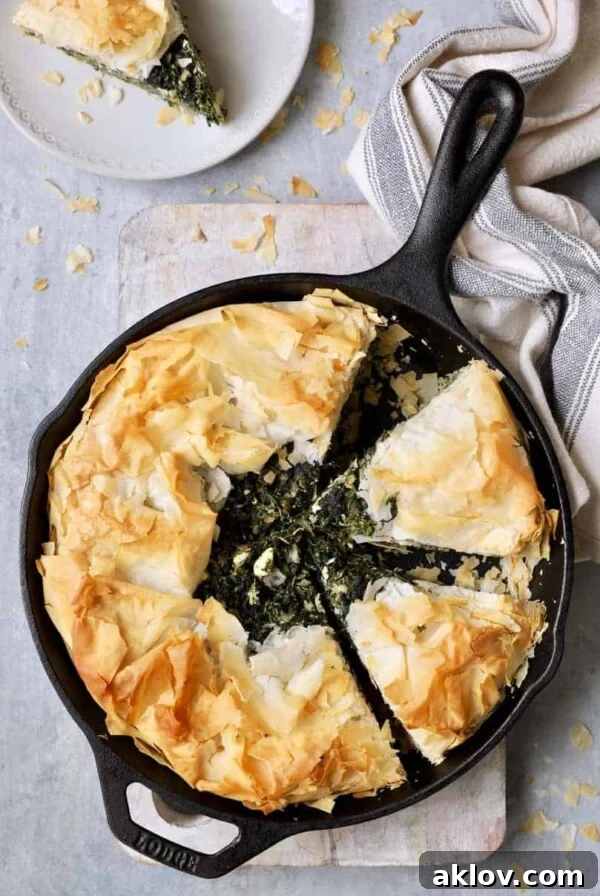Skillet Spanakopita (Greek Spinach and Feta Pie) - Overhead shot in cast iron skillet with gray striped towel