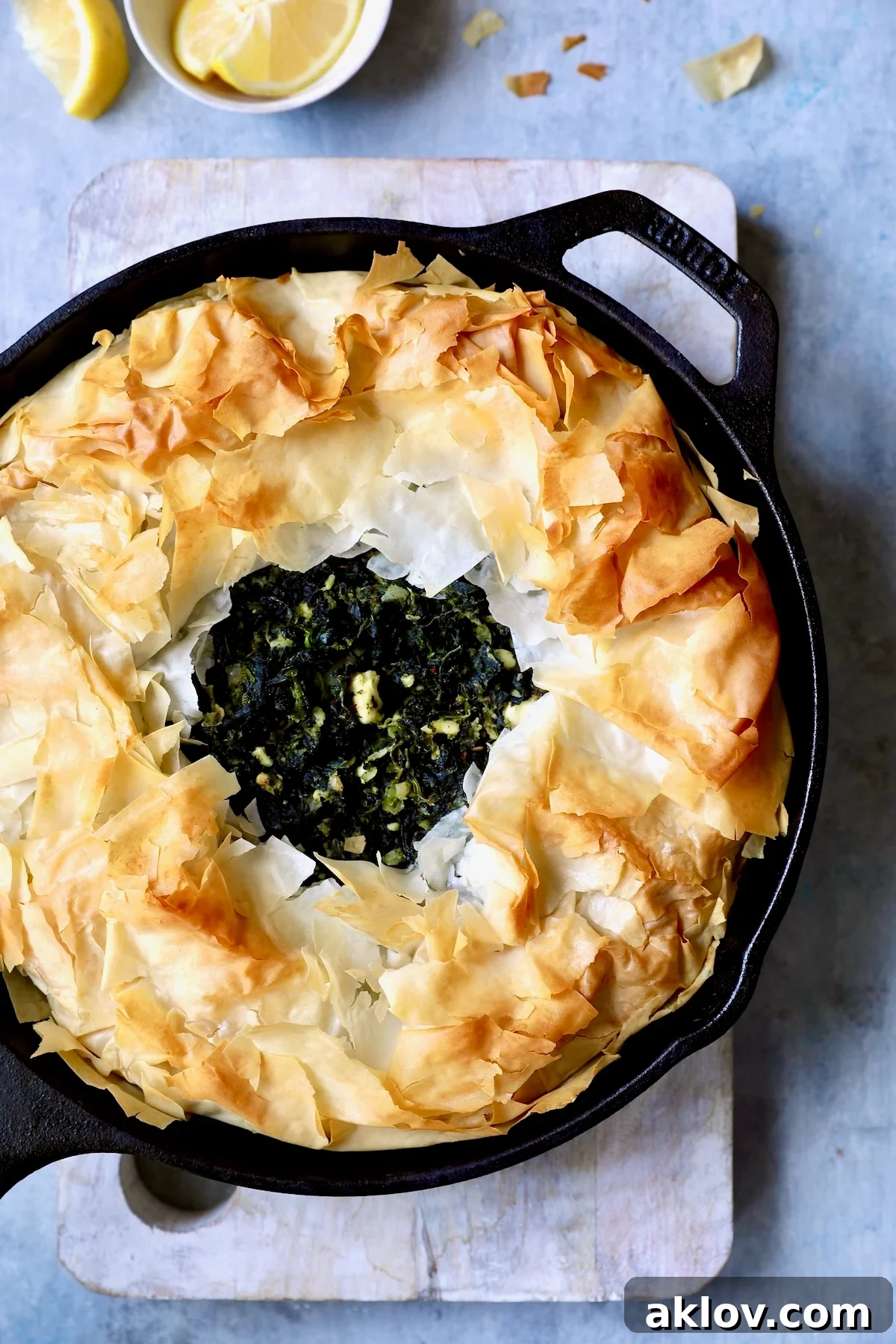 Skillet Spanakopita with Spinach and Feta 3 Close-up photo of baked Skillet Spanakopita, showing the texture of the phyllo and the spinach filling. This image highlights the delicious layers and inviting warmth of the pie.