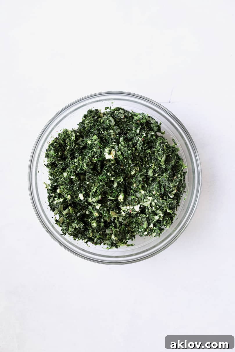 Skillet Spanakopita with Spinach and Feta 8 Photo of combined ingredients for spanakopita filling in a glass bowl, after mixing. The mixture looks uniform and well-incorporated.