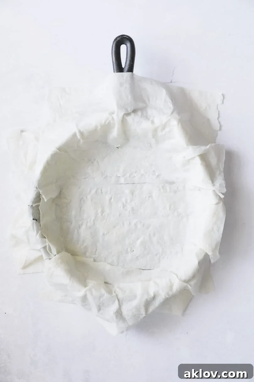 Skillet Spanakopita with Spinach and Feta 10 Photo of multiple layers of phyllo dough artfully arranged over the bottom of a cast iron skillet, creating a rustic base for the pie. This shows the completed phyllo base.