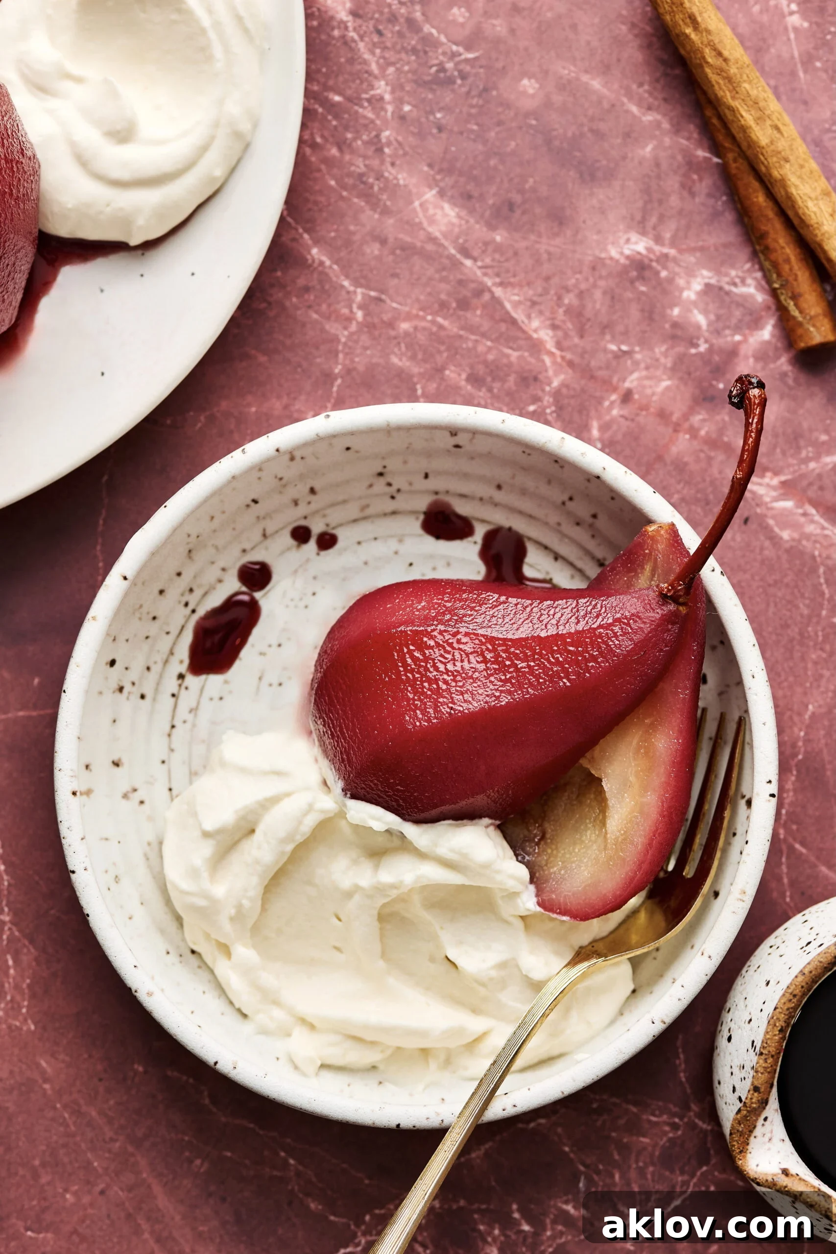 One serving of Red Wine Poached Pears in serving bowl with fork.