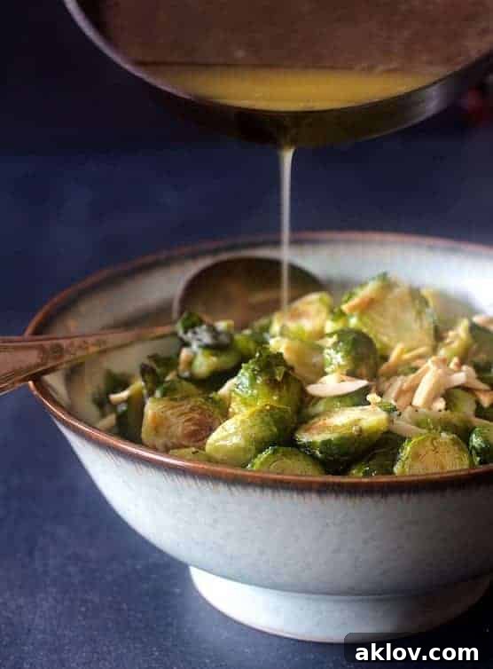 Photo of Roasted Brussels Sprouts with Browned Butter and Almonds with brown butter being poured from saucepan.