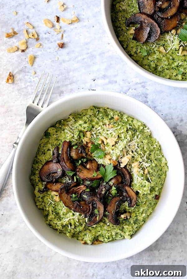 One serving of Oven Risotto with Kale Pesto and Roasted Mushrooms in white dinner bowl.