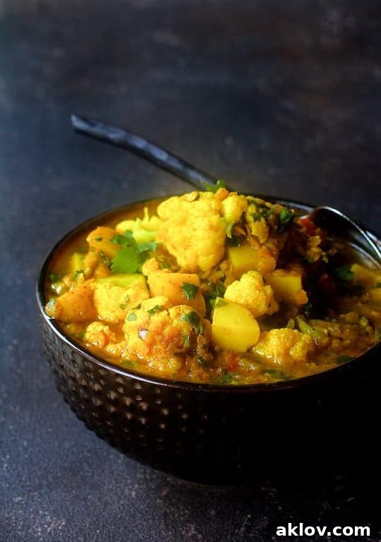 Photo of Cauliflower Red Lentil and Potato Curry in decorative bowl with serving spoon.