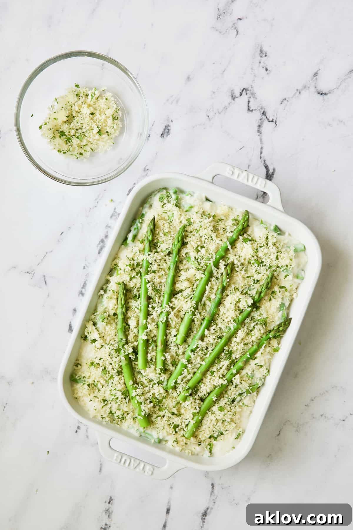 The Creamy Asparagus and Rice Casserole, topped with the panko breadcrumb mixture and whole asparagus stalks, waits patiently in the baking dish before baking.