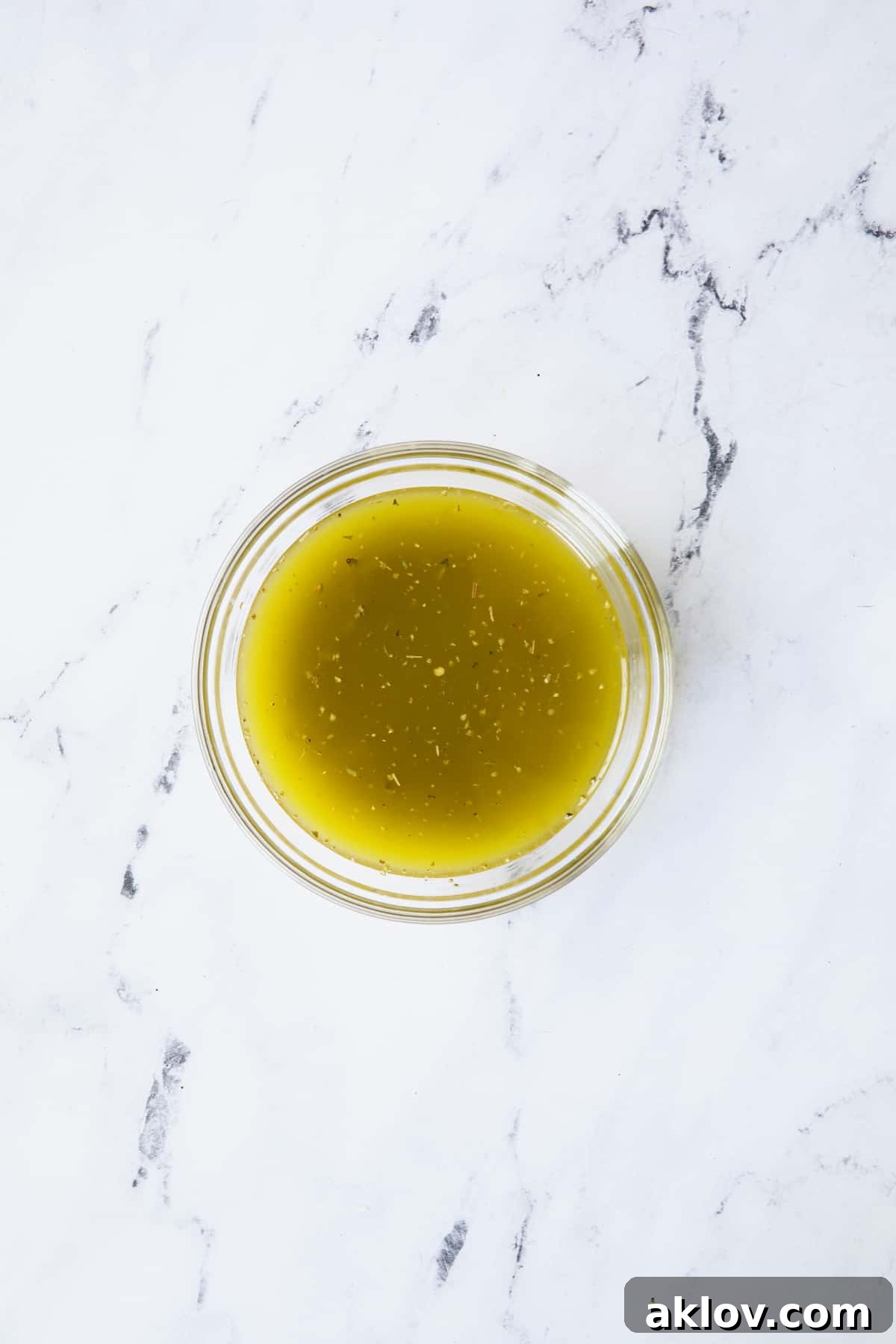 Homemade Italian vinaigrette dressing in a glass bowl.