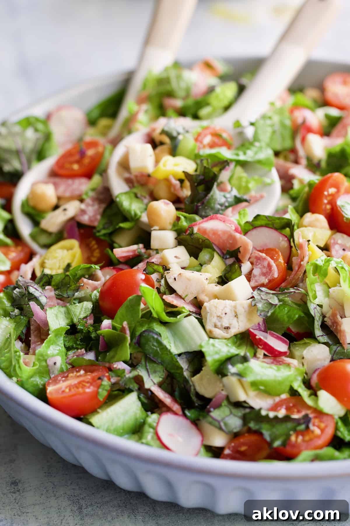 A vibrant Italian Chopped Salad with Chicken, ready to be served with elegant utensils.