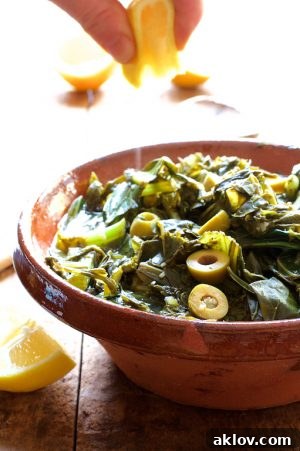 Braised Greens with Olives and Lemon in a beautiful stoneware bowl, ready to serve.