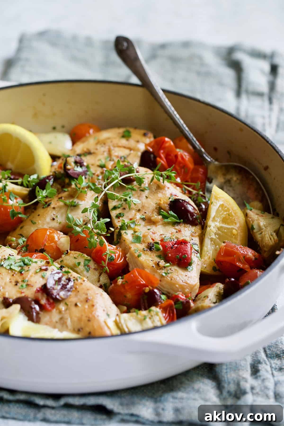 Easy Skillet Mediterranean Chicken in white enamel skillet on blue napkin.