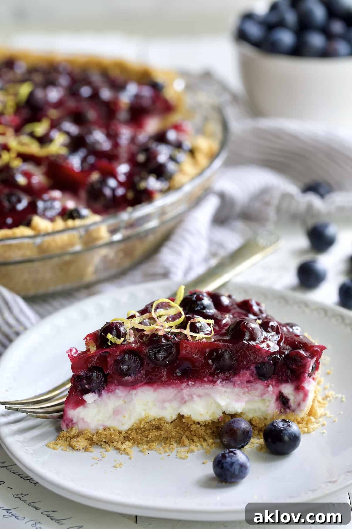 Photo of a slice of Blueberry Cream Cheese Pie on a white plate.