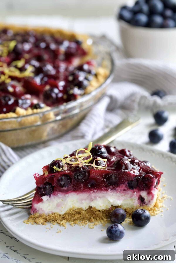 Photo of a slice of Blueberry Cream Cheese Pie on a white plate.