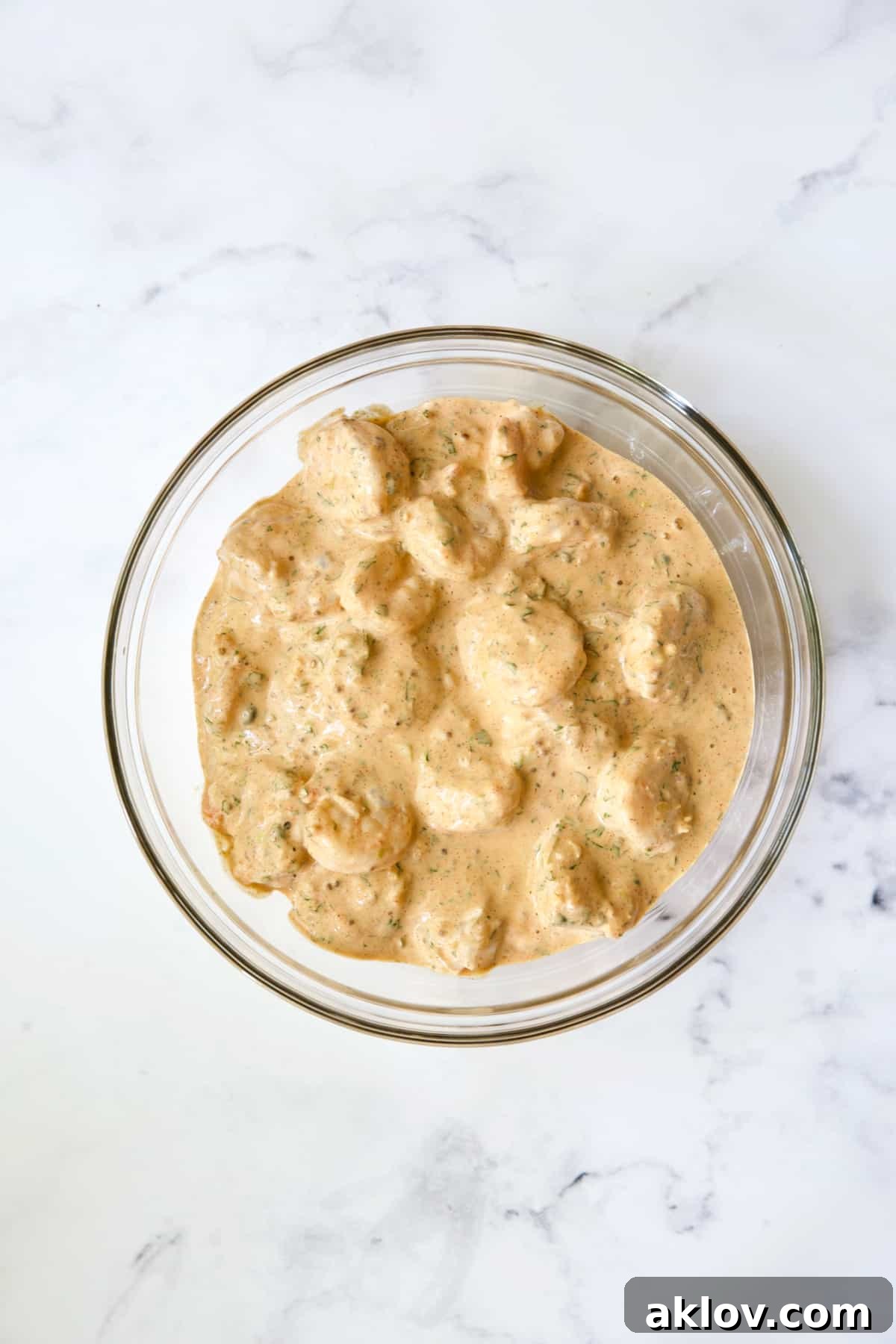 Shrimp in Sriracha Remoulade in glass bowl.
