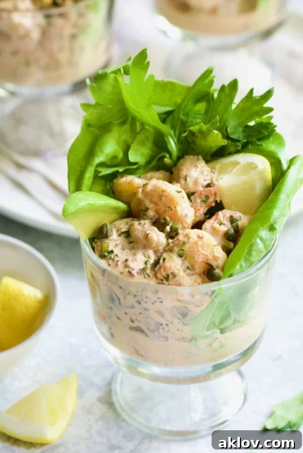 Photo of Sriracha Shrimp Remoulade Cocktail with lettuce, celery leaves, avocado wedge and lemon wedge.