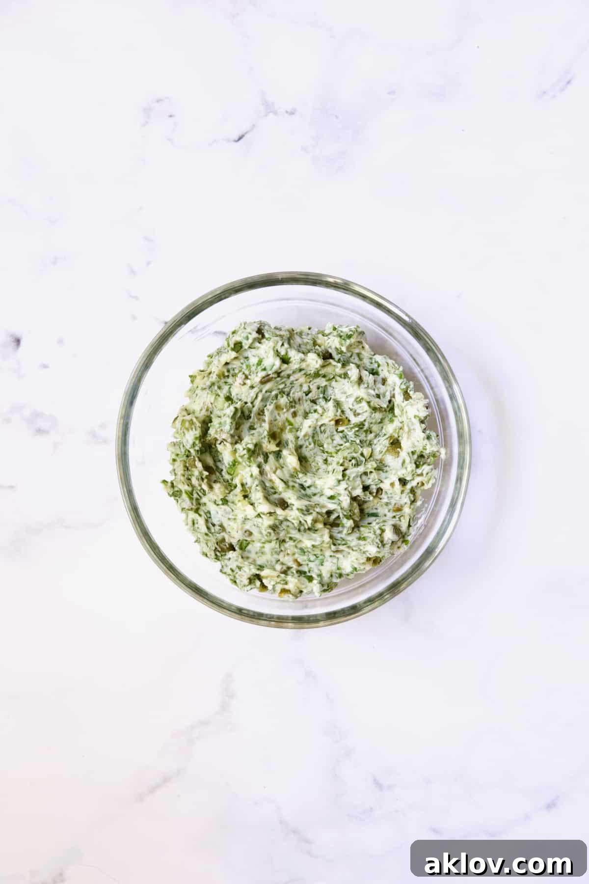 Herb - Caper Butter in glass bowl.