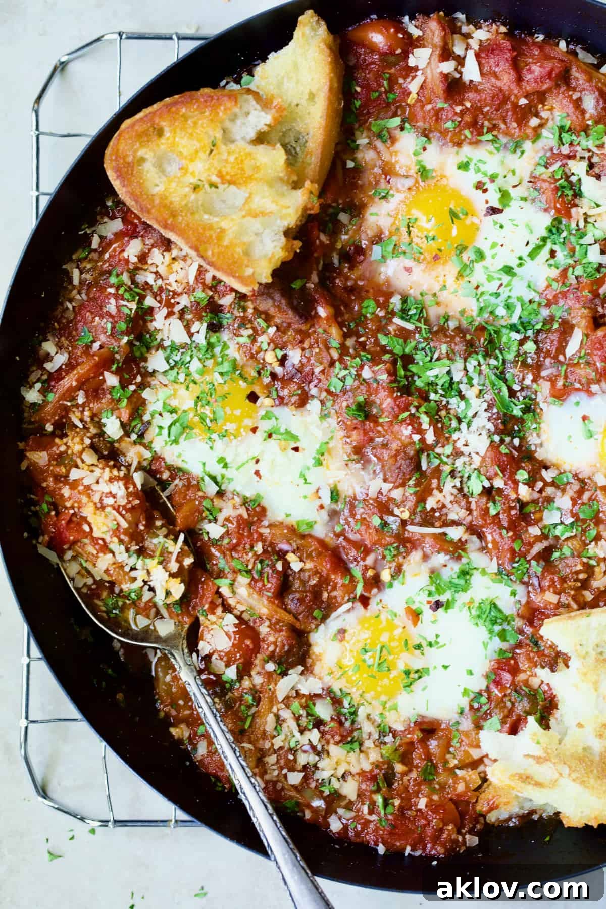 Eggs in Purgatory with Italian Sausage in skillet with toasted bread.