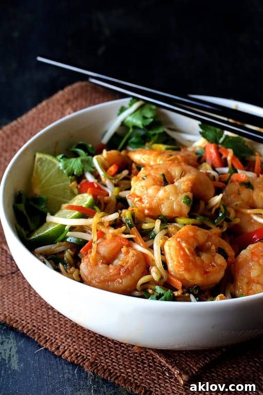 A beautifully plated bowl of Shrimp Pad Thai with Zucchini Noodles, garnished with lime and cilantro, ready to be enjoyed.