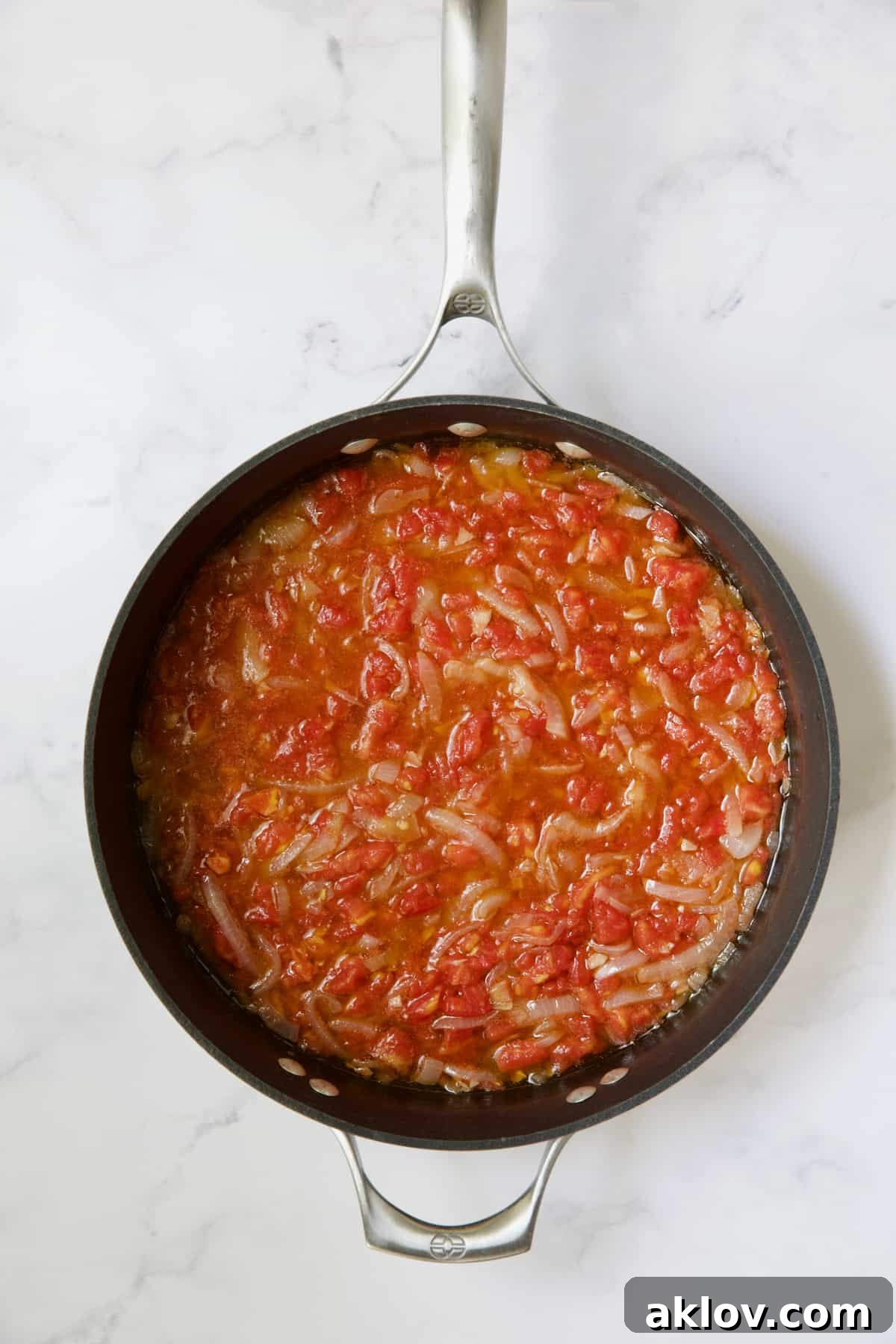Mediterranean Green Bean and Tomato Stew 9 Tomatoes and onions being cooked in skillet.